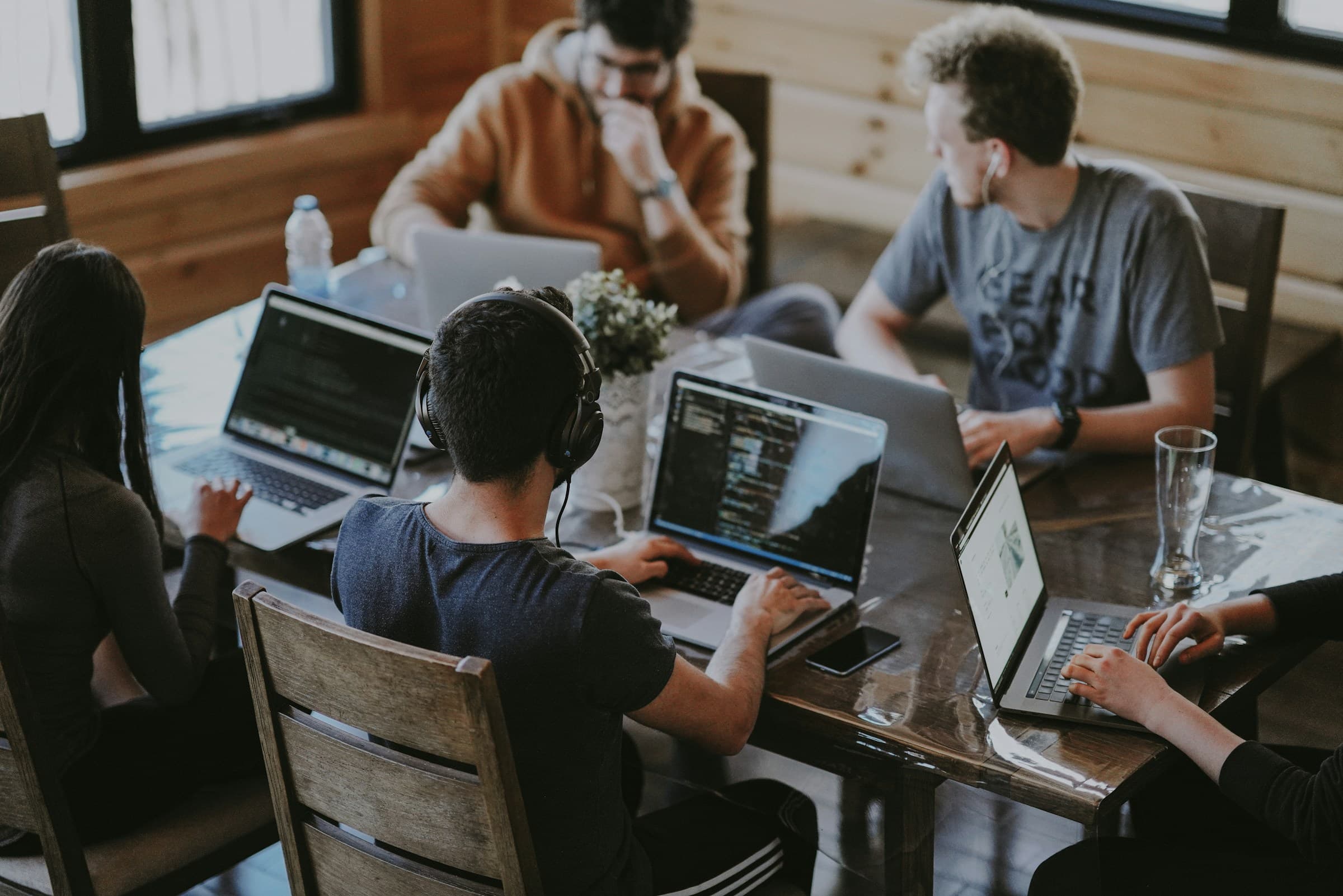 Equipo de trabajo colaborando con laptops en una mesa