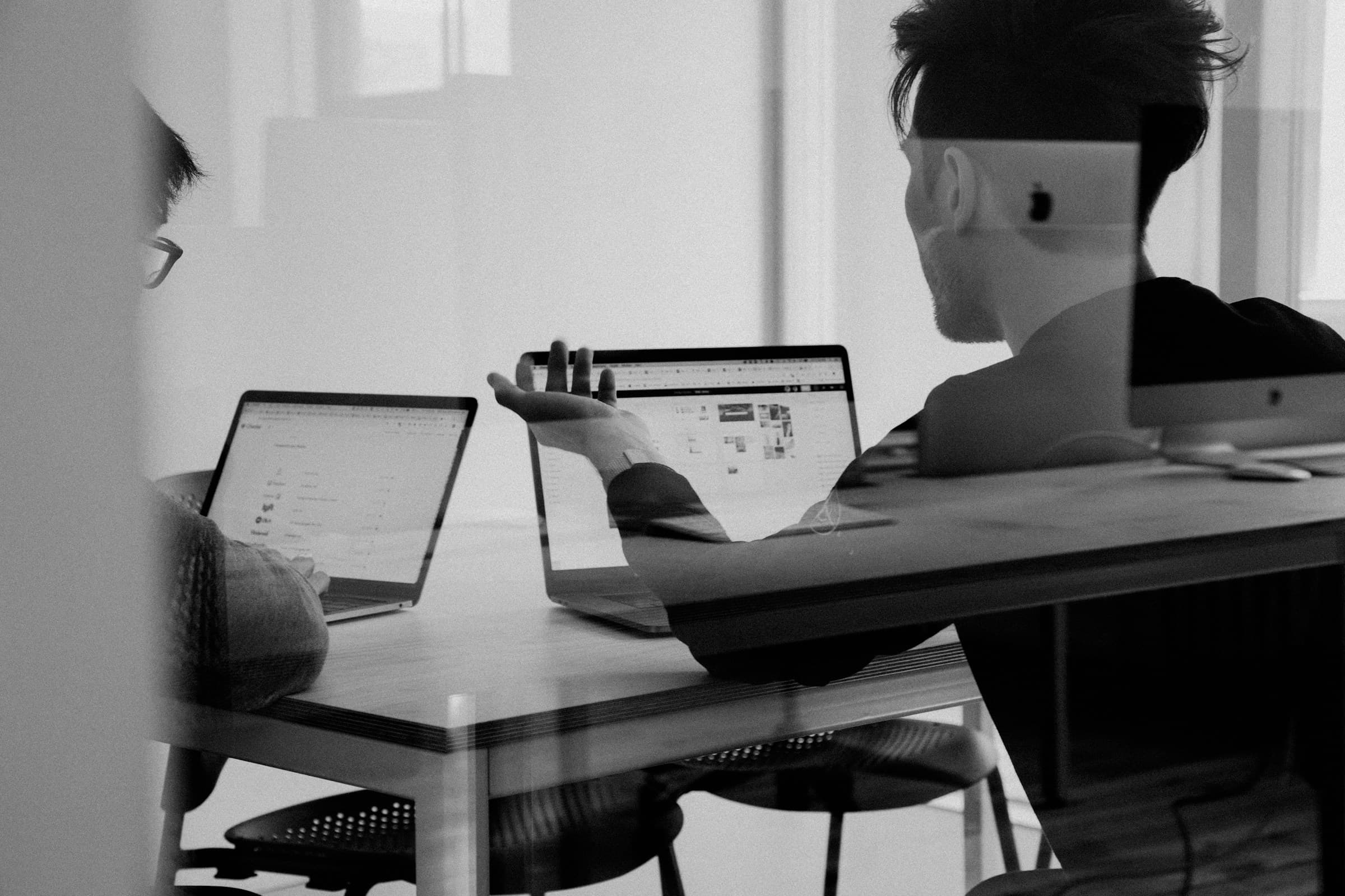 Sesión de trabajo frente a dos pantallas, en blanco y negro
